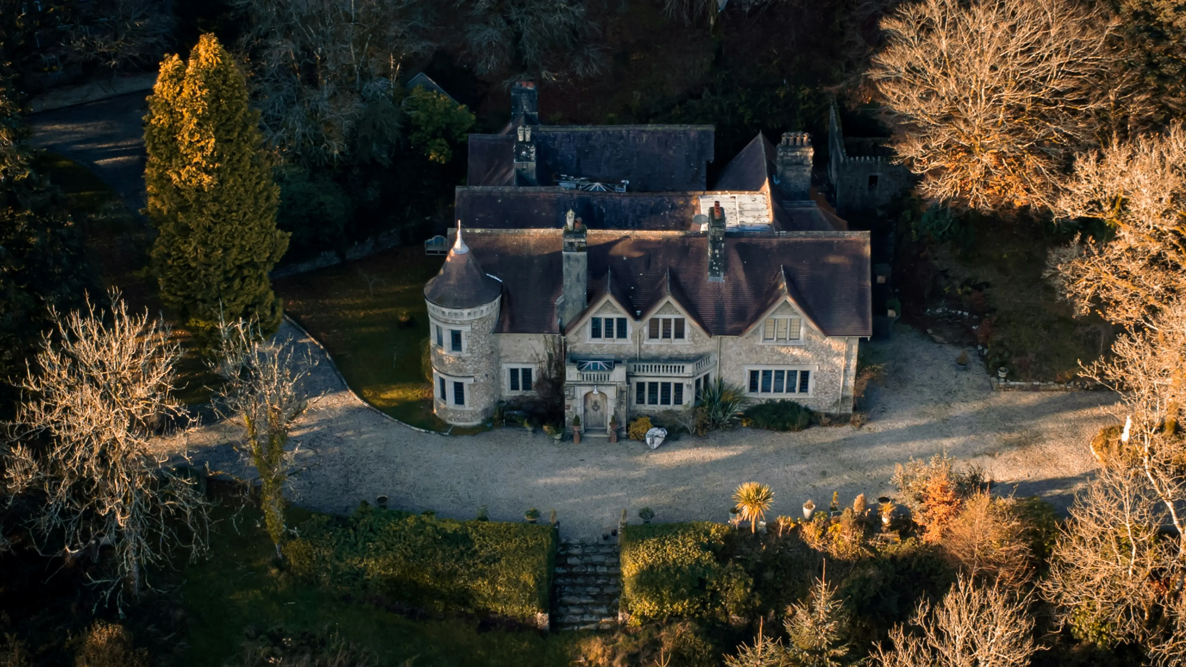 Manoir de caractère avec tourelle au coucher de soleil hivernal, vue aérienne